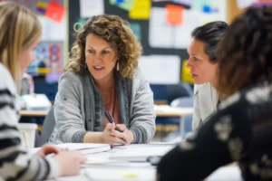 Eine Gruppe von Frauen sitzt in einem Familienzentrum zusammen und führt ein konzentriertes Gespräch bei einem Workshop.